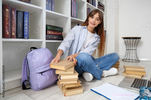 Happy female student with b...