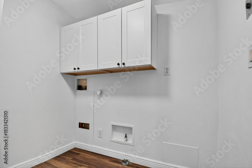Canvas Print Clean Laundry Space With Storage, Wellorganized Laundry Nook Featuring Cabinets