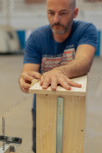 A young craftsman restores a caravan in a hangar.
