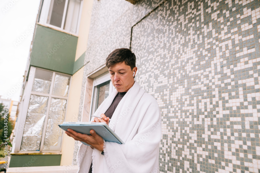 Fototapeta premium Focused student on balcony surrounded by urban nature environment