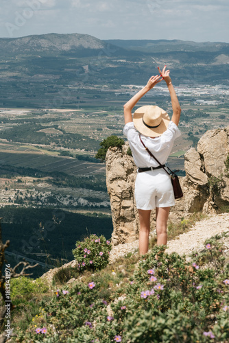 Photos Woman enjoying scenic mountain view in summer outfit with straw hat
