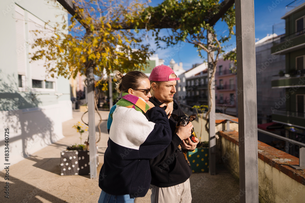 Fototapeta premium Woman embraces partner while they check travel details outdoors