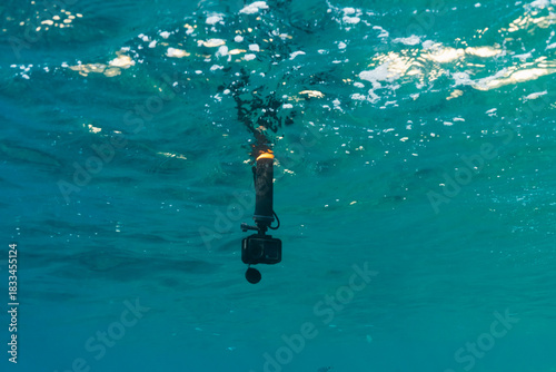 Action camera on a pole submerged underwater in the clear turquoise waves of the Mediterranean Sea near Saint-Jean-Cap-Ferrat, France.