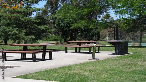 A public picnic area in a suburban Australian park, Wyndham Vale, Melbourne. Featuring picnic tables, a built-in electric BBQ. Concept of outdoor recreation, community facilities, weekend gatherings.