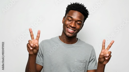Young man expressing positivity with playful peace signs in consecutive movements. joyful confidence shines through playful gestures and smiles.