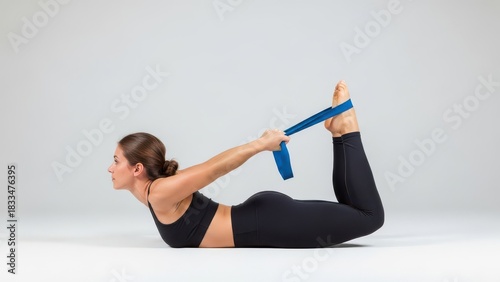 Woman performs yoga bow pose with resistance band for flexibility