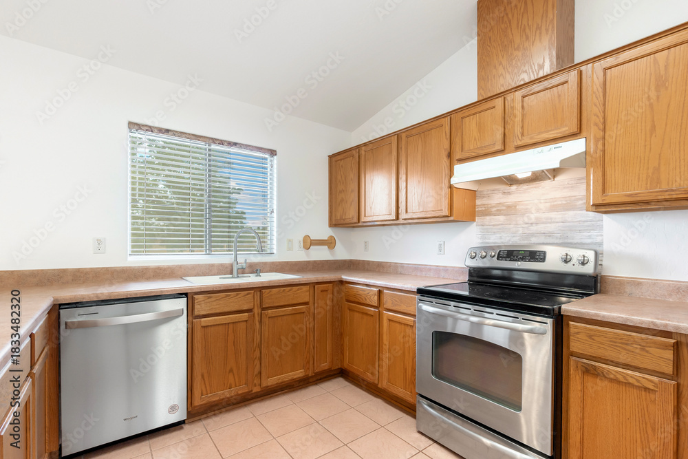 Fototapeta premium A modern kitchen with stainless steel appliances and wooden cabinets