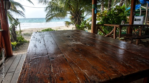 Wooden Table in Beachside Outdoor Restaurant with Ocean View and Tropical Plants