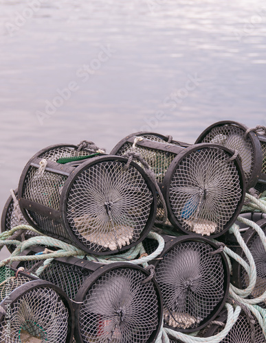 Stacked crab and lobster pots on the pier with sea background