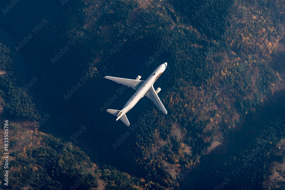 Fototapeta premium Passenger jet viewed from a mountain peak flying below the observer for a breathtaking aerial view