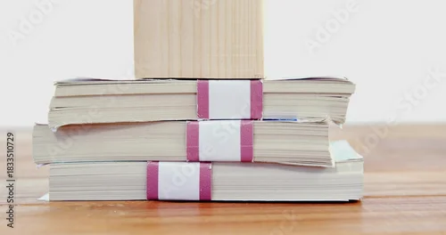 Fototapeta samoprzylepna Displaying three paperback booklets stacked on wood table, showing magenta bands and wood block