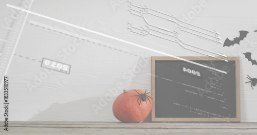 Displaying small orange pumpkin topped with plastic spider on wood table with board, bats, glitch