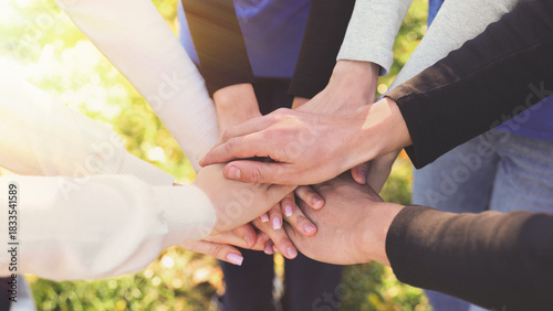 Group of volunteers stacking hands outdoors on sunny day, closeup. Banner design