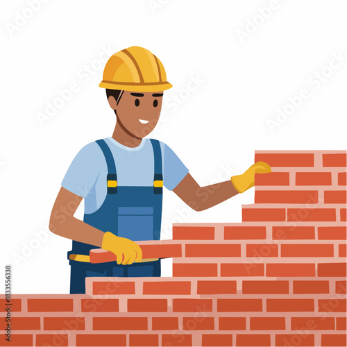 A construction worker wearing a yellow helmet and gloves carefully places a brick on a growing brick wall, building a structure.