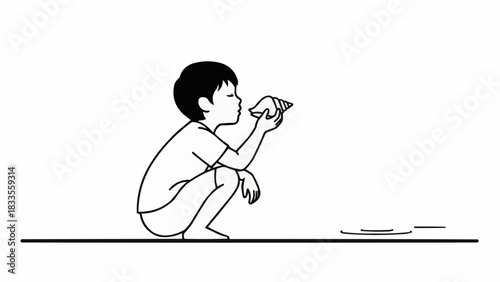 Young boy in profile examining a seashell with intense focus.