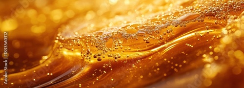 Liquid honey close up shows golden swirls and trapped air bubbles