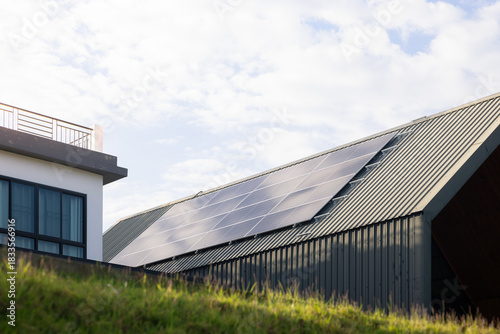 Wallpaper Mural Sustainable Home for Saving Energy, modern house designed with solar panels installed on metal roof sheet, smart home technology for reducing electricity costs. Concept of smart saving. Torontodigital.ca