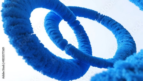 Close-up of intertwined blue fuzzy rings against a light background