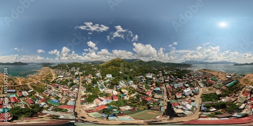 High altitude 360 equirectangular aerial view directly above colorful rooftops of Coron town center near the bay