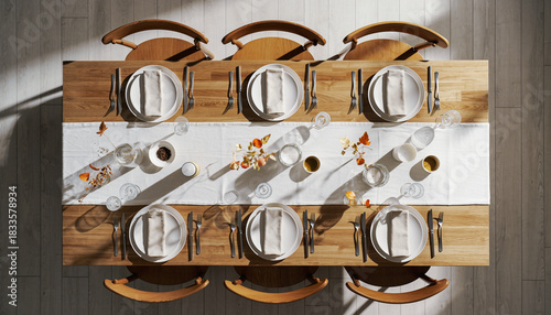 Top view of an elegant wooden dining table set for a dinner party with minimalist decor