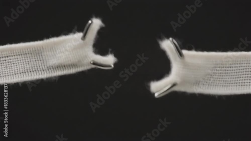 Close-up of a white shoelace with metal tips against a black background.