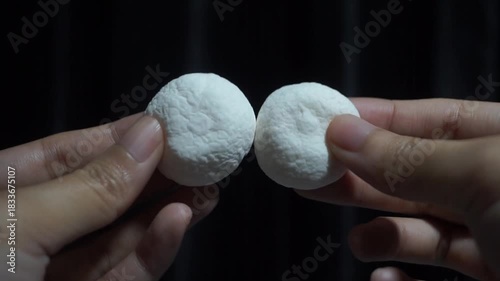 Hands Gently Squeeze Two Soft White Candy Balls