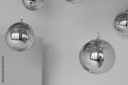 Chrome spheres hang in a minimalist space.