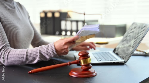 justice and law concept. Female judge in a courtroom the gavel, working with smart phone and laptop and digital tablet computer on white table