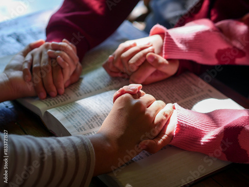 group of people praying together while holding hand on holy bible book at church. Concept of hope, religion, faith, christianity and god blessing.