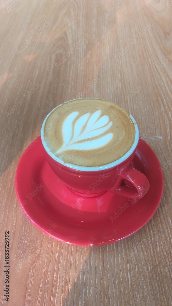 Obraz premium Coffe latte on the red cup photo,latte on the red cup stock photo,latte coffe on the red cup potrait,coffe late photo on the red cup stock photo 