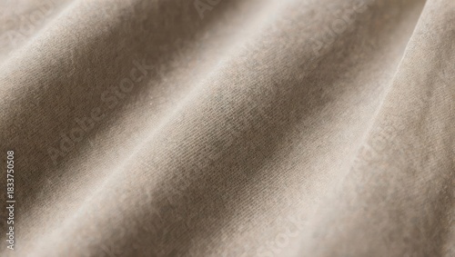 Close-up of a light beige fabric, exhibiting soft folds and subtle texture