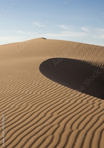 Vast undulating sandy dunes stretch across a barren landscape under a clear sky, showcasing the arid environment's natural beauty ,pattern ,nature ,heat