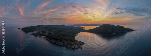 Panoramic sunrise aerial of Sakatia Island, Nosy Be, Madagascar – golden light over the ocean, tropical coastline, and peaceful island landscape.