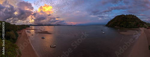 Panoramic sunrise aerial of Sakatia Island, Nosy Be, Madagascar – golden light over the ocean, tropical coastline, and peaceful island landscape.