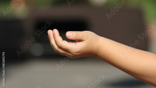 Child's forearm and cupped hand extended outward in an open gesture