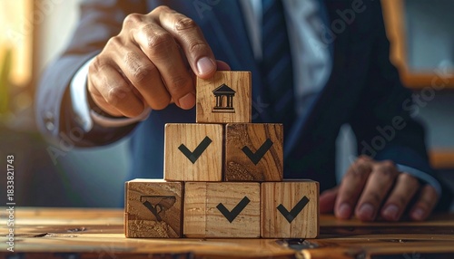 Professional hand carefully places building block atop stack symbolizing successful financial strategy and approval process