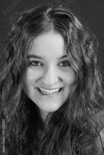 Portrait einer jungen Frau die in die Kamera blickt und lächelt