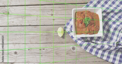 Placing square bowl with tomato dip, cilantro, lime on gingham-cloth on rustic wood, copy space