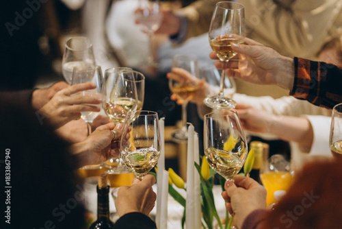 Hands toasting wine glasses at celebratory dinner event