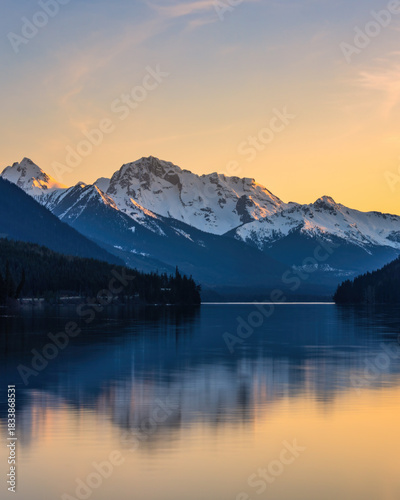 Duffey Lake reflecting snow capped mountains at sunset in Canada
