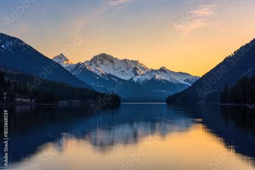 Duffey Lake reflecting snow capped mountains at sunset in Canada