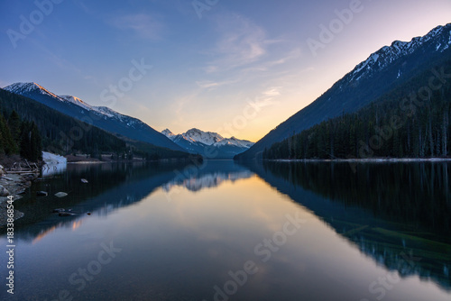 Duffey Lake reflecting snow capped mountains at sunset in Canada