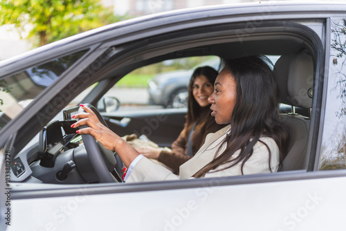 Diverse women sharing a ride, commuting, and having friendly conversation in a modern vehicle during daytime
