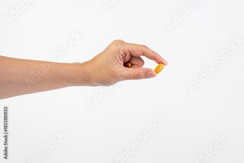 Medicine or vitamins in hand on white background