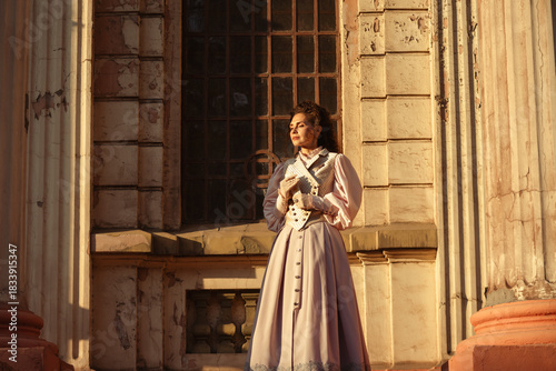 Wallpaper Mural A woman in an antique dress holds a letter close to her heart near the columns of an old cathedral. Torontodigital.ca