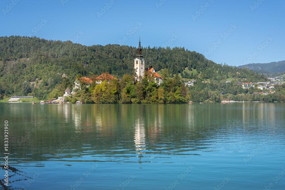 Fototapeta premium Pilgrimage Church of the Assumption of Mary (Bled Island Church). Bled Island. Stunning Panoramic View of Lake Bled with Iconic Island and Castle, Slovenia. Romantic spot. Water reflection.