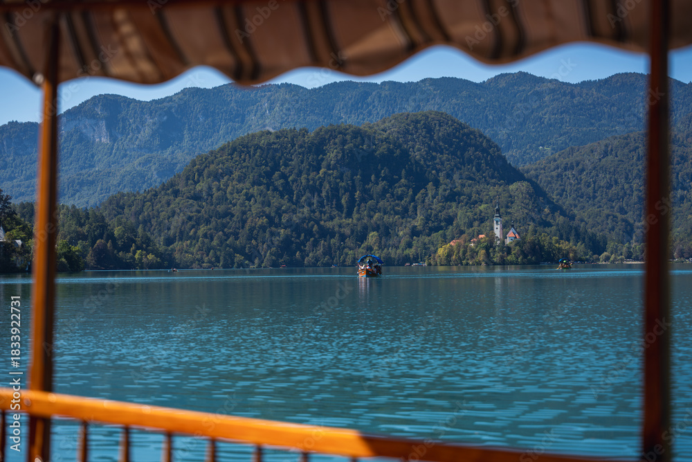 Fototapeta premium Pilgrimage Church of the Assumption of Mary (Bled Island Church). Bled Island. Stunning Panoramic View of Lake Bled with Iconic Island and Castle, Slovenia. Romantic spot. Typical Bled boat (Pletna).