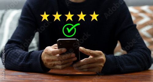 Customer pressing on smartphone with five star icon for feedback review satisfaction service