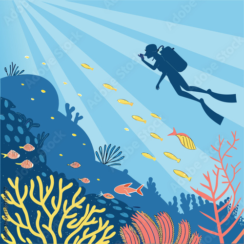 Scuba diver swimming over coral reef with fish