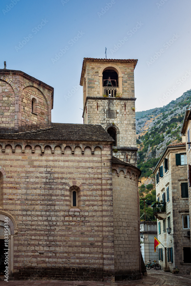 Fototapeta premium The bell tower or campanile of the Church of St. Mary Collegiate or the church of St. Osanna in the city of Kotor at dawn. Montenegro. Vertical view.